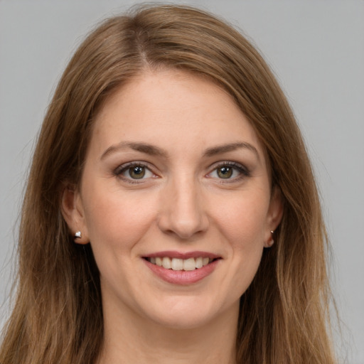 Joyful white young-adult female with long  brown hair and green eyes