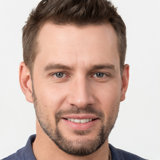 Joyful white young-adult male with short  brown hair and grey eyes