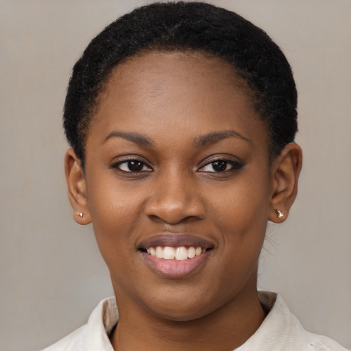 Joyful black young-adult female with short  black hair and brown eyes
