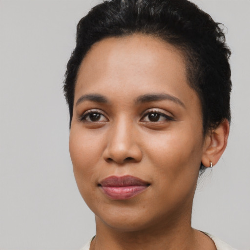 Joyful latino young-adult female with short  black hair and brown eyes