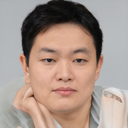 Joyful asian young-adult male with short  brown hair and brown eyes