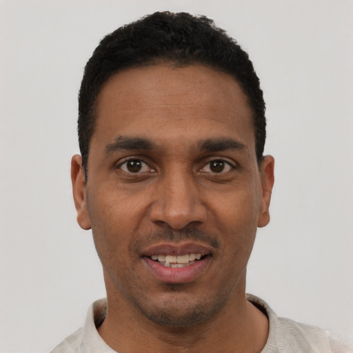 Joyful black young-adult male with short  black hair and brown eyes