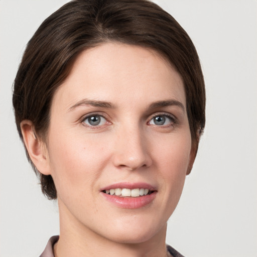 Joyful white young-adult female with short  brown hair and grey eyes