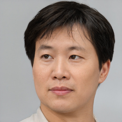 Joyful asian adult male with short  brown hair and brown eyes