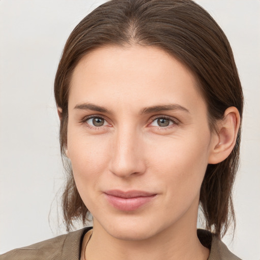 Joyful white young-adult female with medium  brown hair and grey eyes