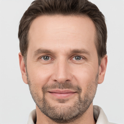 Joyful white adult male with short  brown hair and brown eyes