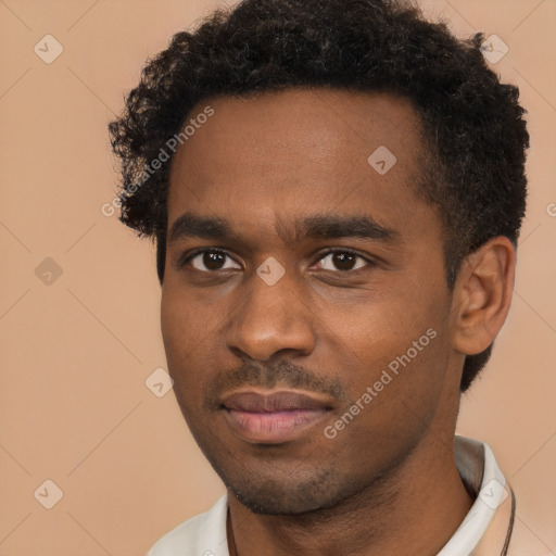 Joyful black young-adult male with short  brown hair and brown eyes