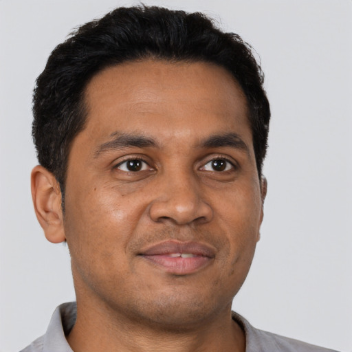 Joyful latino young-adult male with short  brown hair and brown eyes