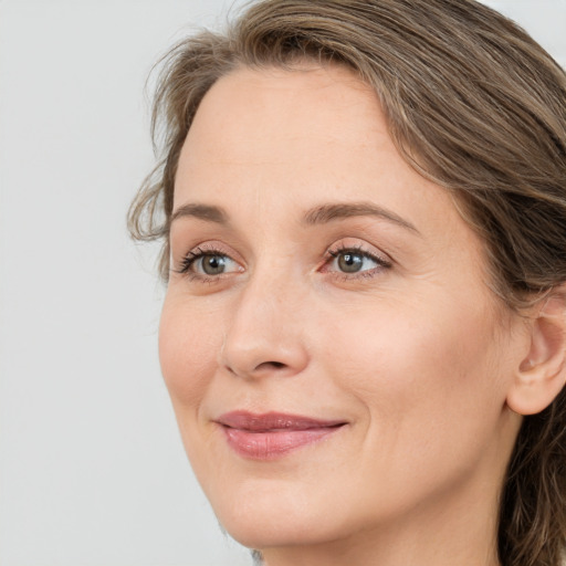 Joyful white young-adult female with long  brown hair and green eyes