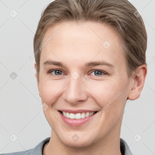 Joyful white young-adult female with short  brown hair and grey eyes