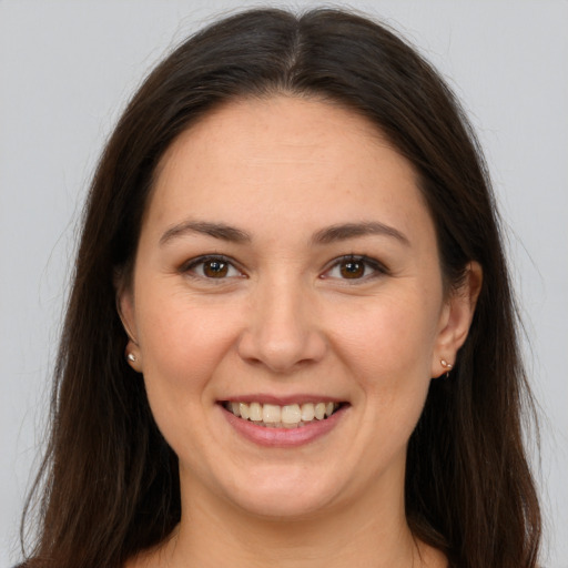 Joyful white young-adult female with long  brown hair and brown eyes