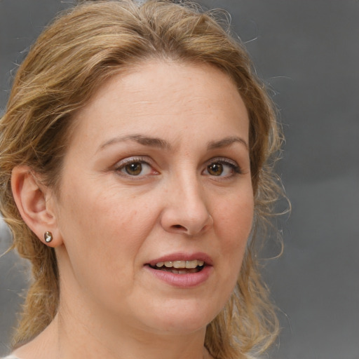 Joyful white adult female with medium  brown hair and brown eyes