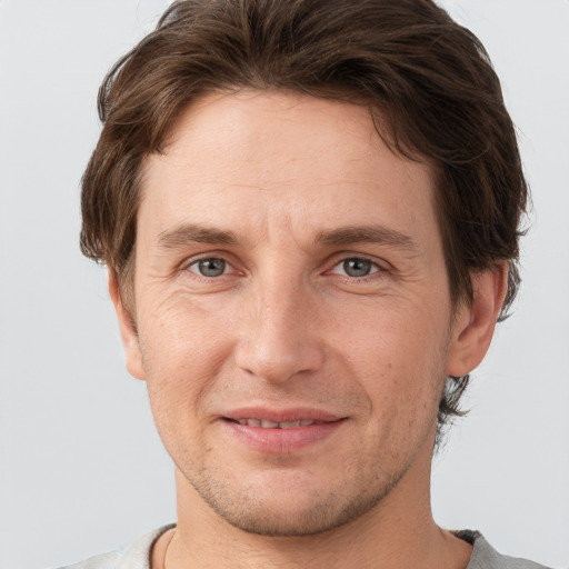 Joyful white adult male with short  brown hair and grey eyes