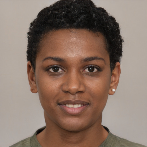 Joyful black young-adult female with short  black hair and brown eyes