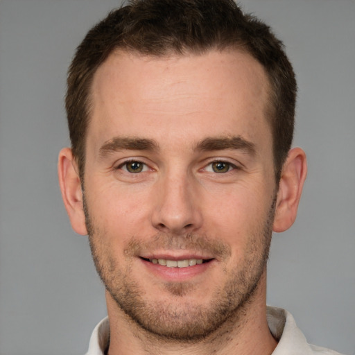 Joyful white young-adult male with short  brown hair and grey eyes