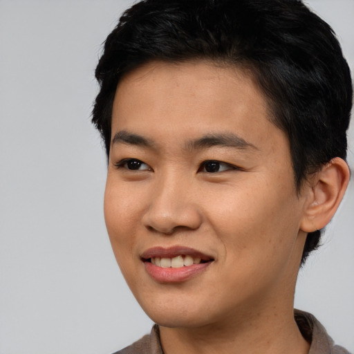 Joyful asian young-adult male with short  black hair and brown eyes