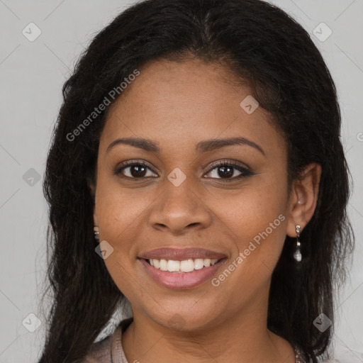 Joyful black young-adult female with long  brown hair and brown eyes