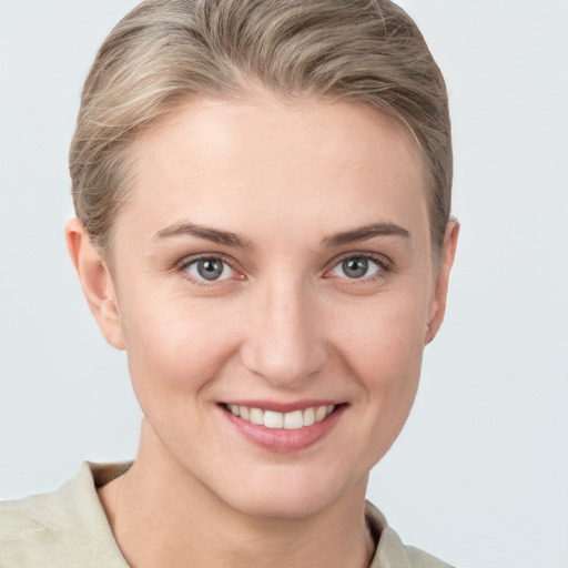 Joyful white young-adult female with short  brown hair and grey eyes