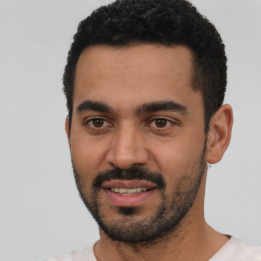Joyful latino young-adult male with short  black hair and brown eyes