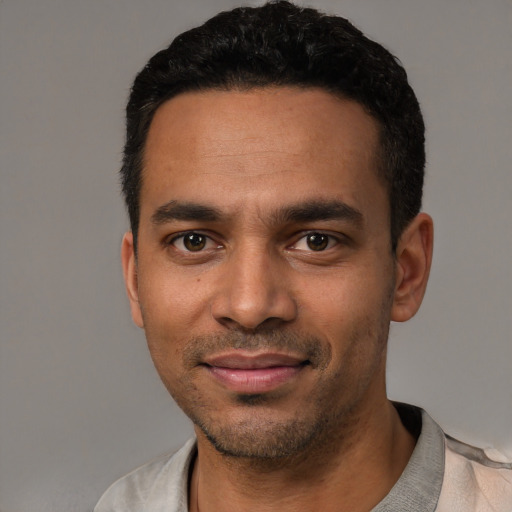 Joyful latino young-adult male with short  black hair and brown eyes
