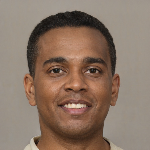 Joyful latino young-adult male with short  brown hair and brown eyes