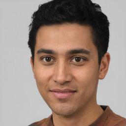 Joyful latino young-adult male with short  black hair and brown eyes