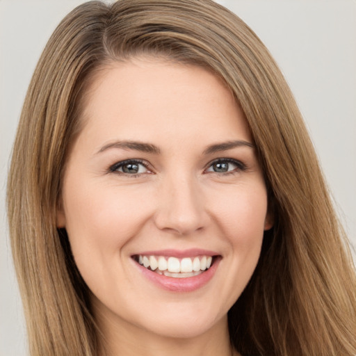 Joyful white young-adult female with long  brown hair and brown eyes