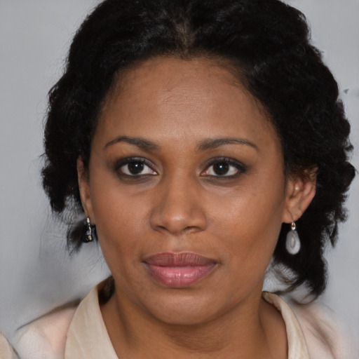 Joyful black adult female with medium  brown hair and brown eyes