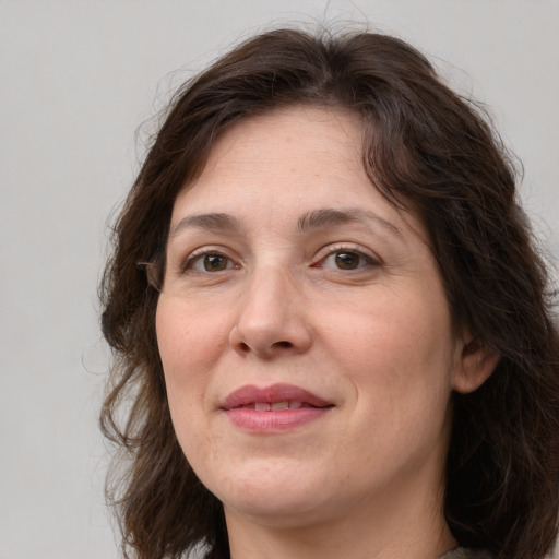 Joyful white adult female with medium  brown hair and grey eyes