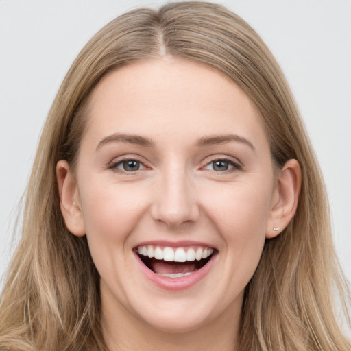 Joyful white young-adult female with long  brown hair and grey eyes