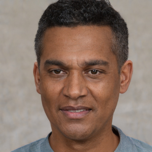 Joyful black adult male with short  black hair and brown eyes