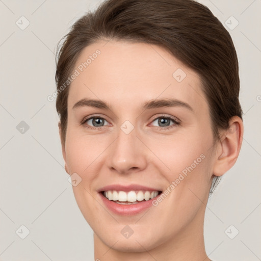 Joyful white young-adult female with short  brown hair and grey eyes