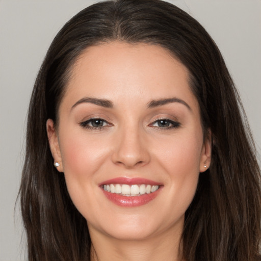 Joyful white young-adult female with long  brown hair and brown eyes