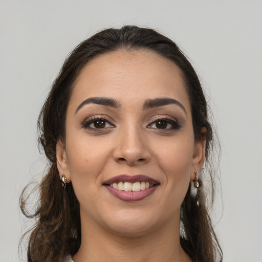Joyful white young-adult female with long  brown hair and brown eyes