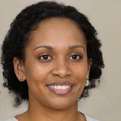 Joyful black young-adult female with medium  brown hair and brown eyes