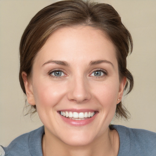 Joyful white young-adult female with medium  brown hair and grey eyes