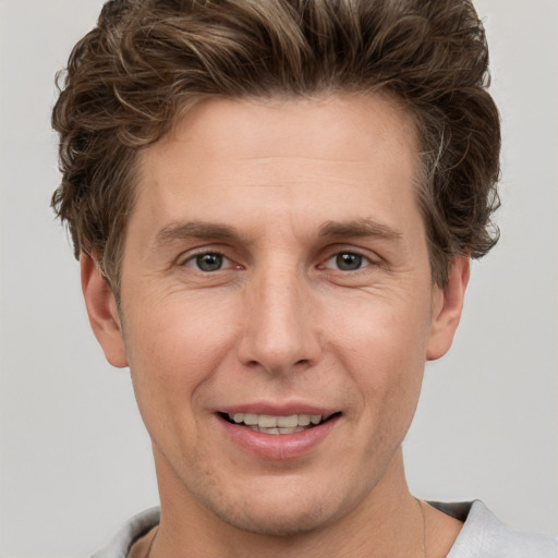 Joyful white adult male with short  brown hair and grey eyes