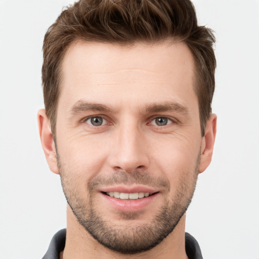 Joyful white young-adult male with short  brown hair and grey eyes