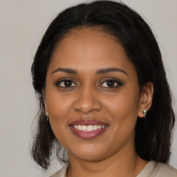 Joyful black young-adult female with medium  brown hair and brown eyes