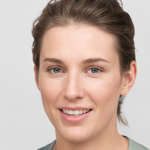 Joyful white young-adult female with short  brown hair and grey eyes