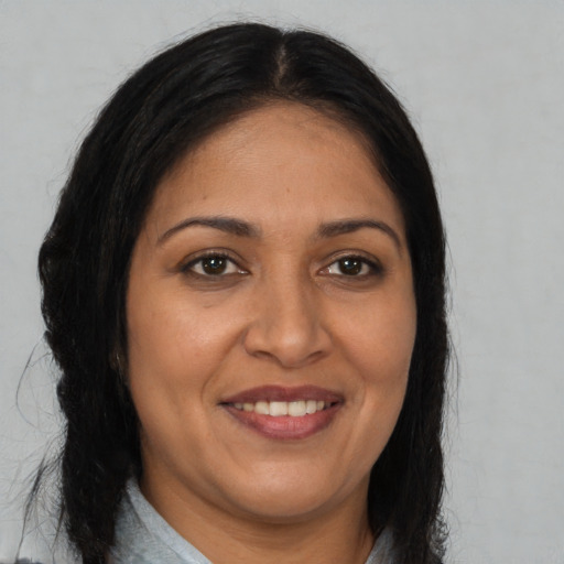 Joyful latino adult female with long  brown hair and brown eyes