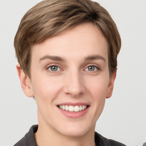 Joyful white young-adult female with short  brown hair and grey eyes