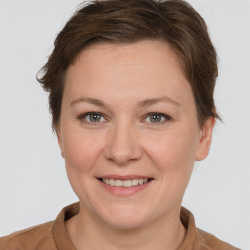 Joyful white young-adult female with short  brown hair and grey eyes