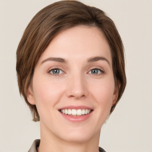 Joyful white young-adult female with medium  brown hair and grey eyes