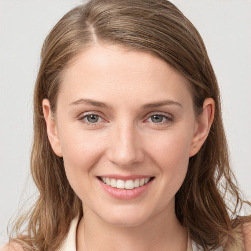 Joyful white young-adult female with long  brown hair and grey eyes