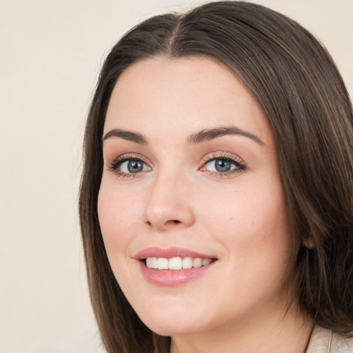 Joyful white young-adult female with long  brown hair and green eyes