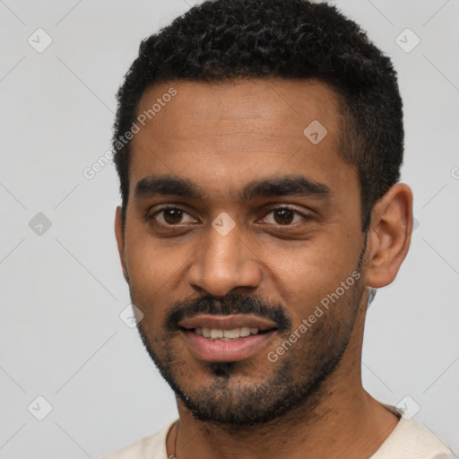 Joyful black young-adult male with short  black hair and brown eyes