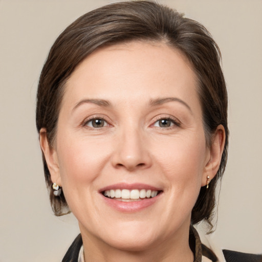 Joyful white adult female with medium  brown hair and grey eyes