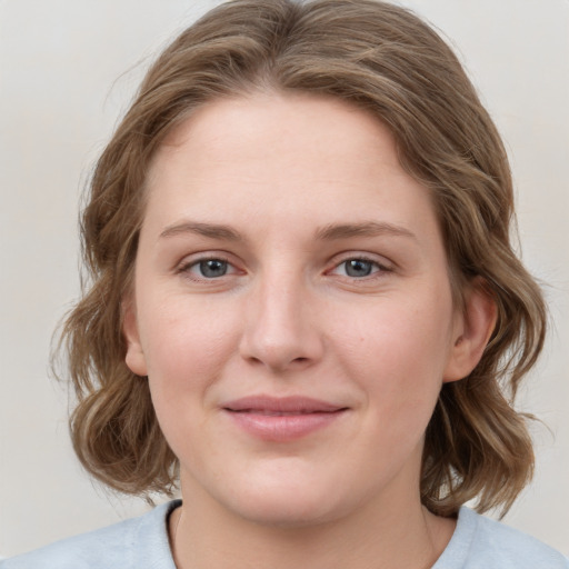 Joyful white young-adult female with medium  brown hair and blue eyes