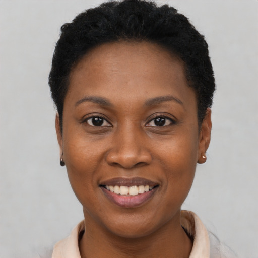 Joyful black young-adult female with short  black hair and brown eyes